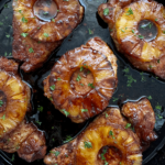 close up shot of Baked Pineapple Teriyaki Pork Chops in a black cast iron skillet