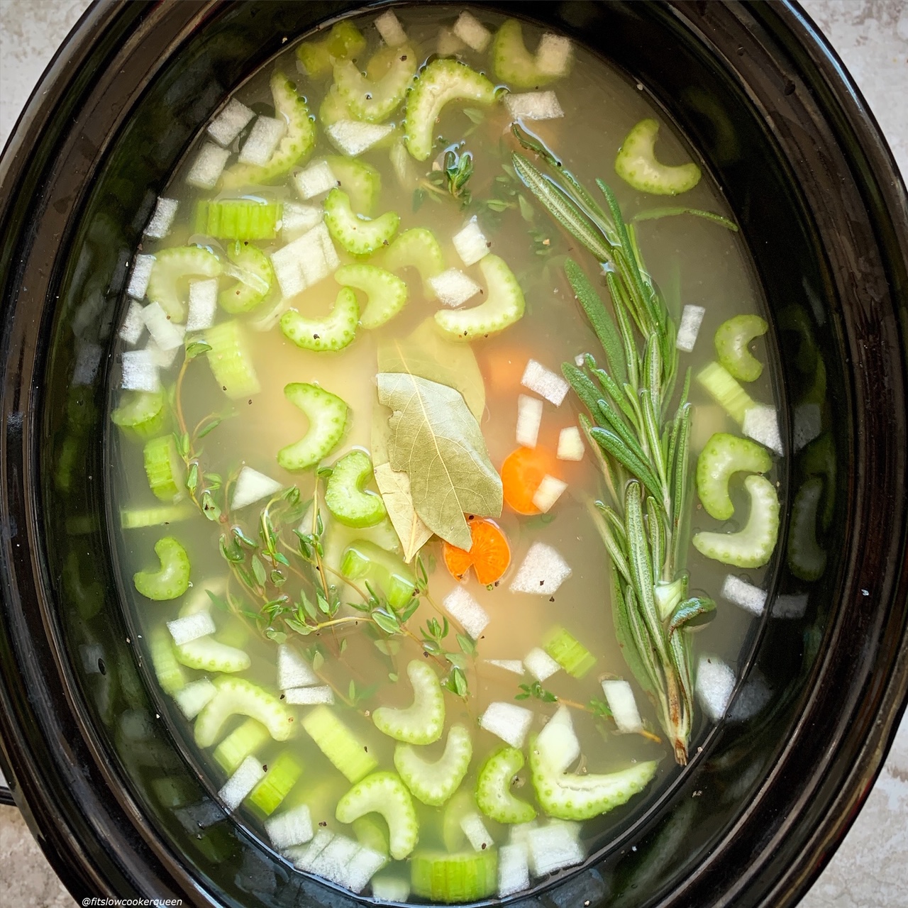 pic of raw chicken, broth, celery, onion, and carrots in the slow cooker for Slow Cooker Instant Pot Chicken Soup (Low-Carb, Paleo, Whole30) (1)
