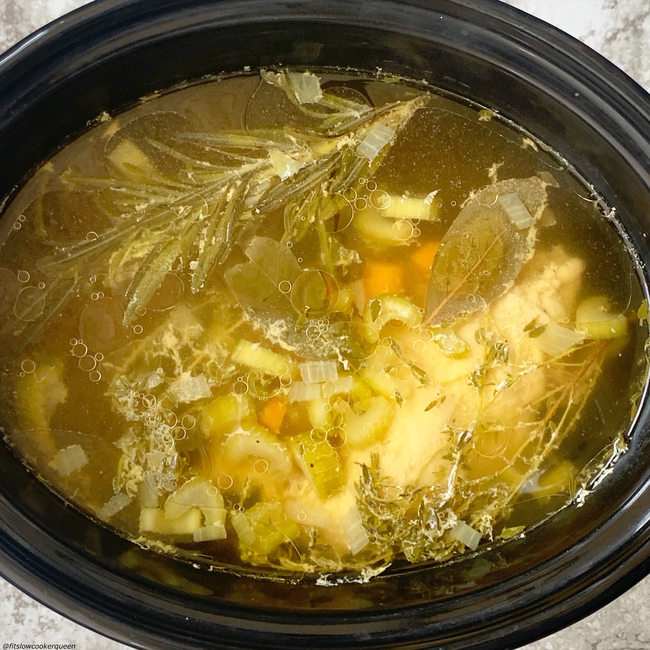 after cooking pic of chicken, broth, celery, onion, and carrots in the slow cooker for Slow Cooker Instant Pot Chicken Soup (Low-Carb, Paleo, Whole30) (1)