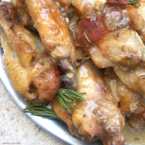 overhead shot of cooked honey mustard chicken wings on a white plate