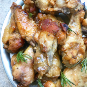 overhead shot of cooked honey mustard chicken wings on a white plate