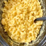 overhead shot of cooked mac and cheese in a black slow cooker