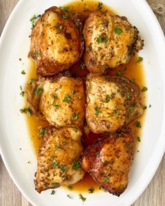 cooked chicken with sauce on top on a white plate