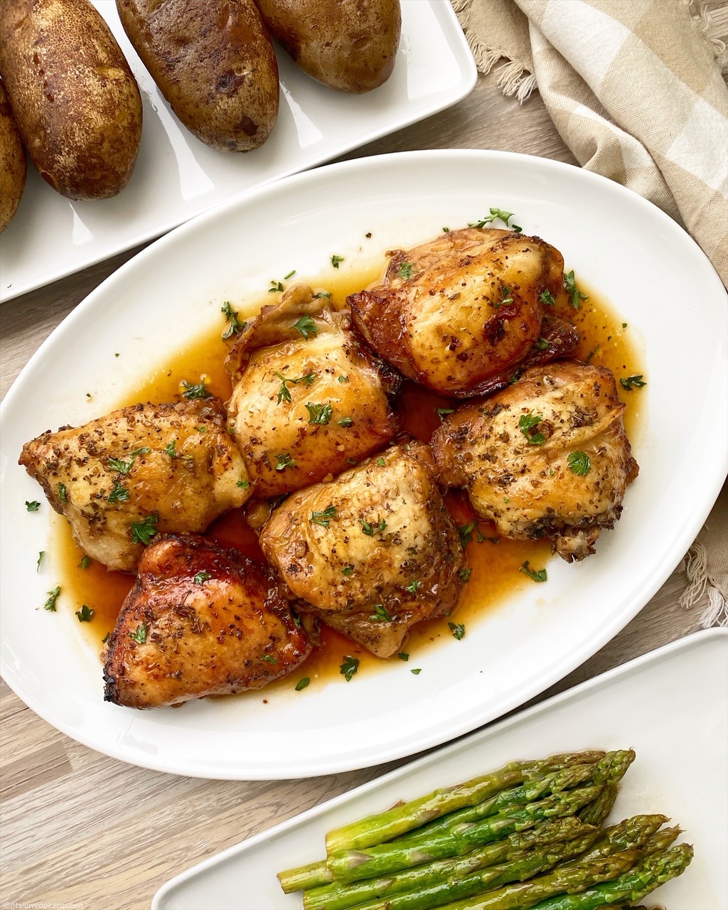 baked potatoes, asparagus, and chicken on white plate