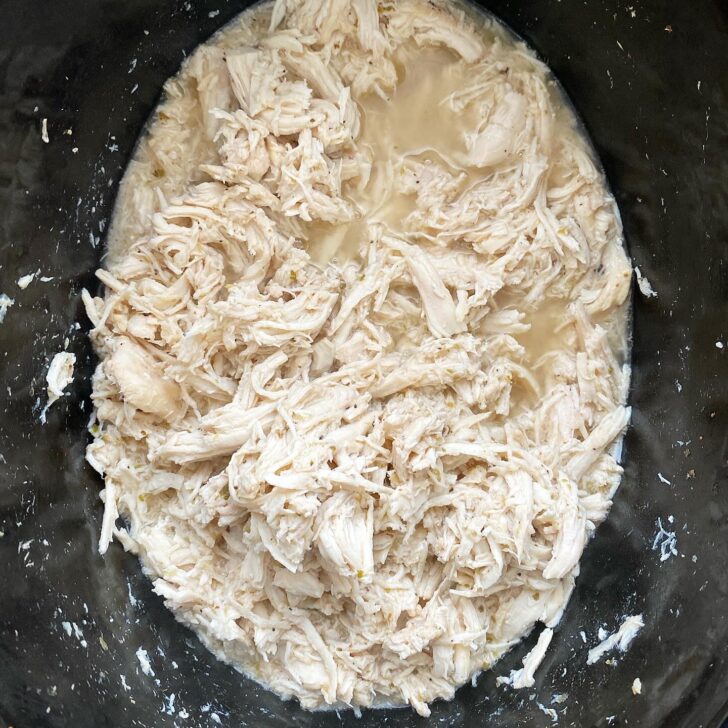 overhead shot of cooked Greek shredded chicken in the slow cooker