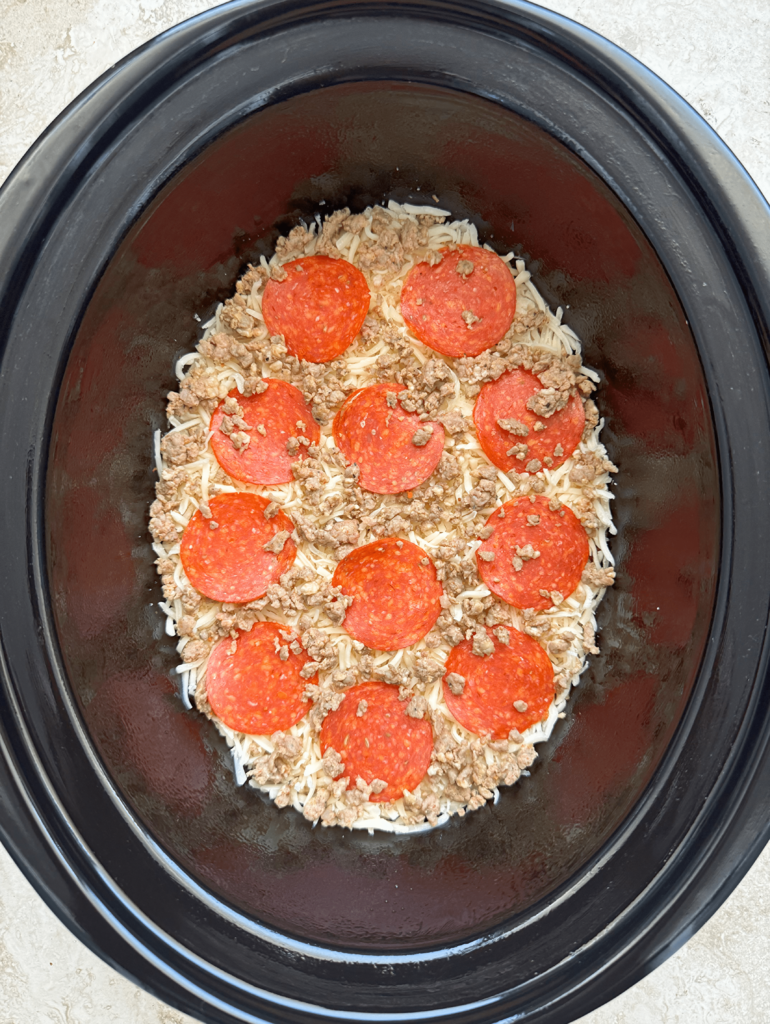 overhead shot of un cooked spaghetti squash pizza with pepperoni and sausage