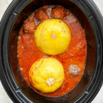 overhead shot of cooked spaghetti squash meatballs in a black slow cooker