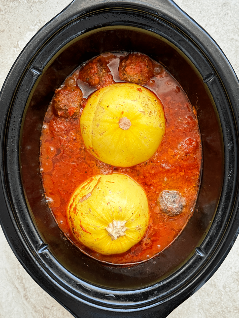 overhead shot of cooked spaghetti squash meatballs in a black slow cooker