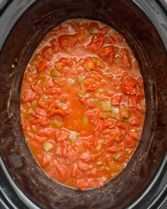 overhead shot of cooked slow cooker shakshuka in a black slow cooker