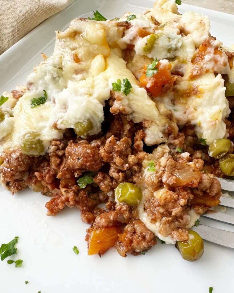 close up shot of cooked Slow Cooker Shepherds Pie on a white plate