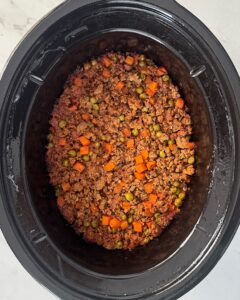 overhead shot of cooked shepherd's pie in a black slow cooker