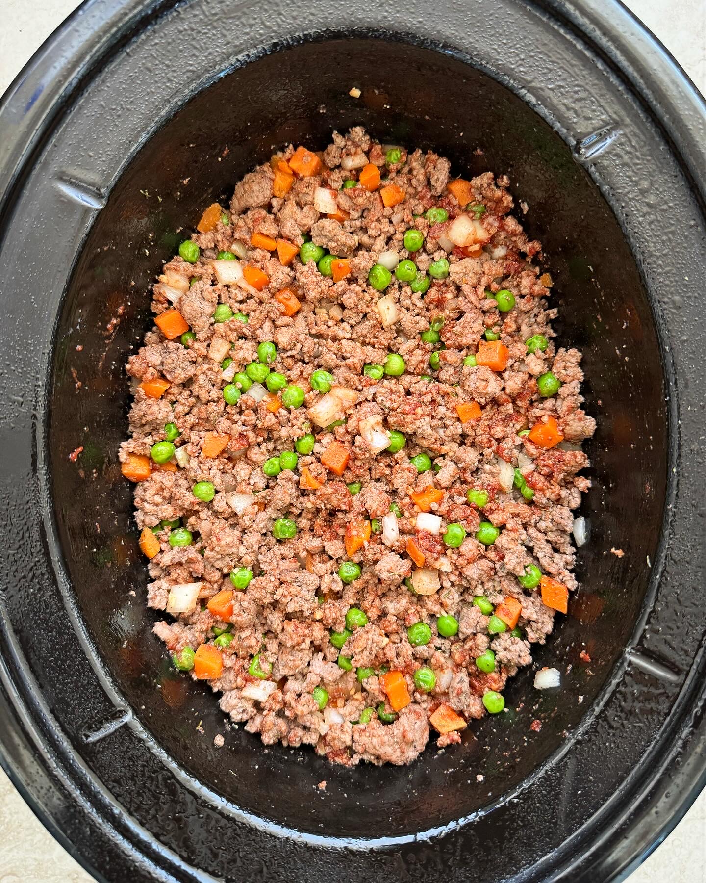 overhead shot of cooked Slow Cooker Shepherds Pie in a black slow cooker, 
