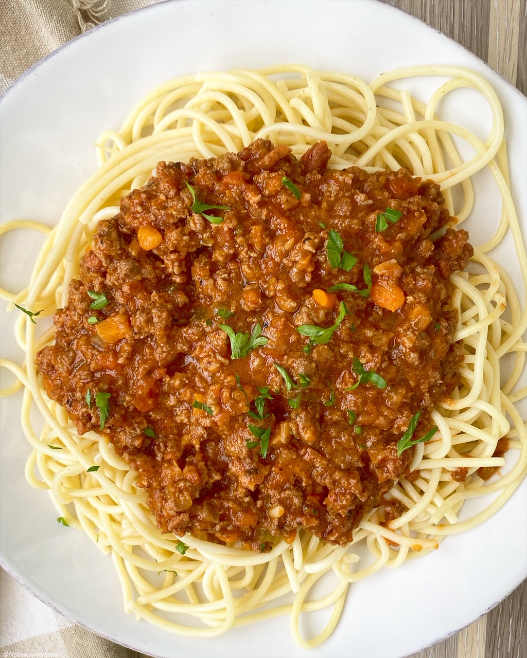 cooked bolognese served over a plate of spaghetti noodles
