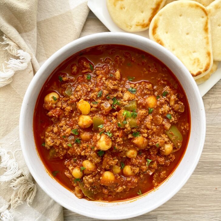 indian chili in a bowl with a side of naan