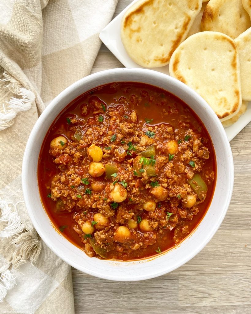 indian chili in a bowl with a side of naan