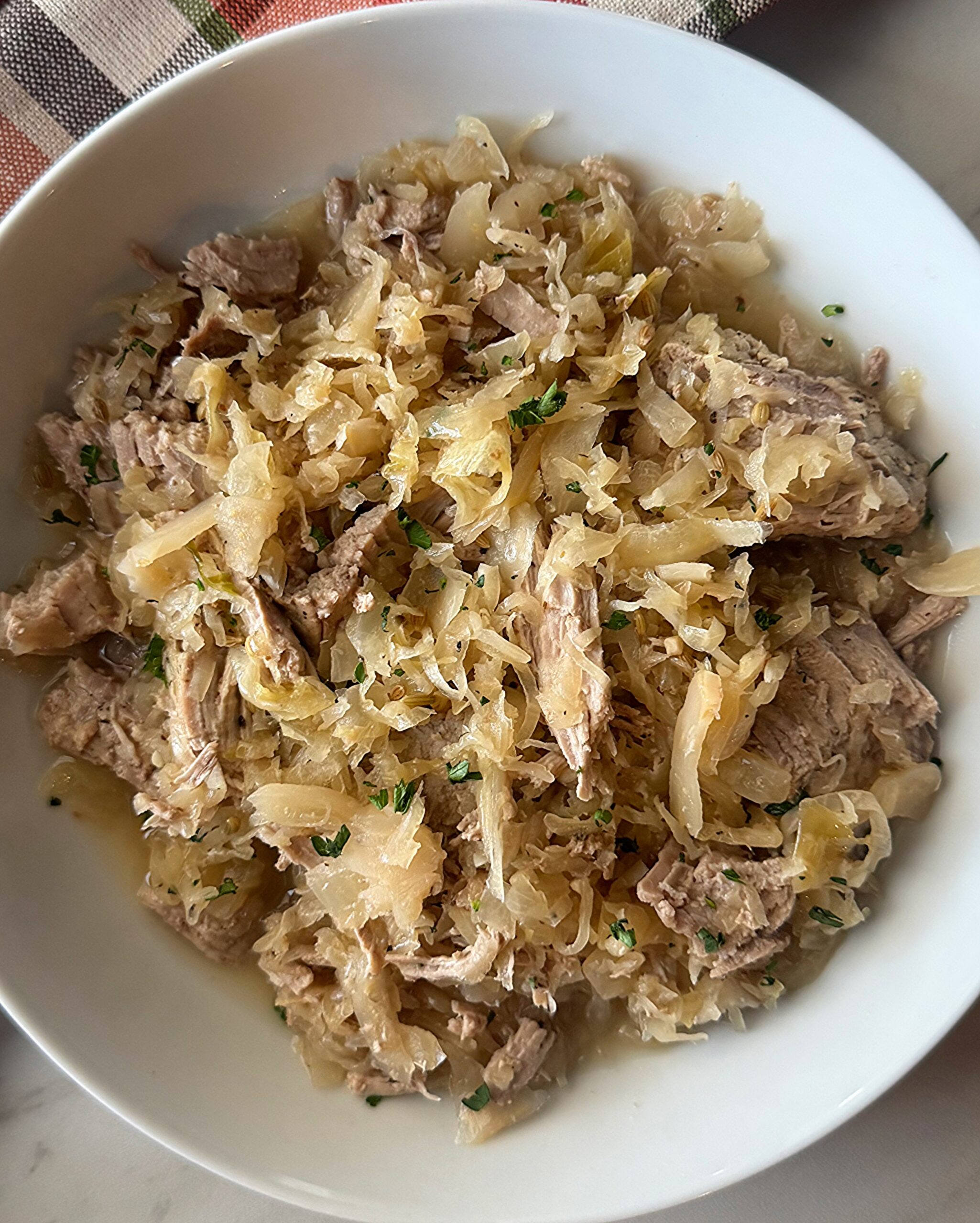 overhead shot of Pork and Sauerkraut on a white plate