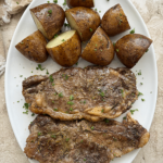 overhead shot of crockpot steak and potatoes on a white plate