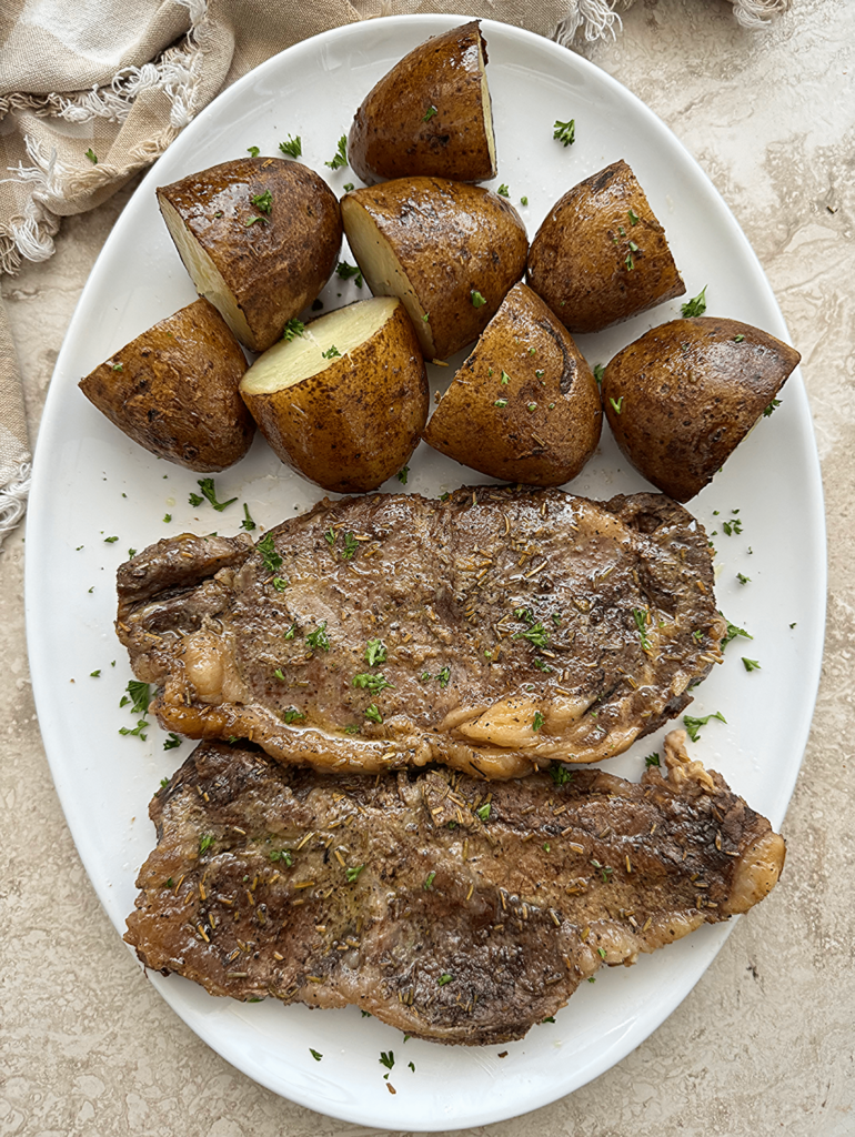overhead shot of crockpot steak and potatoes on a white plate