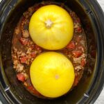 overhead shot of cooked spaghetti squash, meat, tomatoes in a black slow cooker