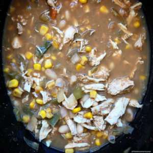 overhead shot of cooked white chicken chili in a black slow cooker