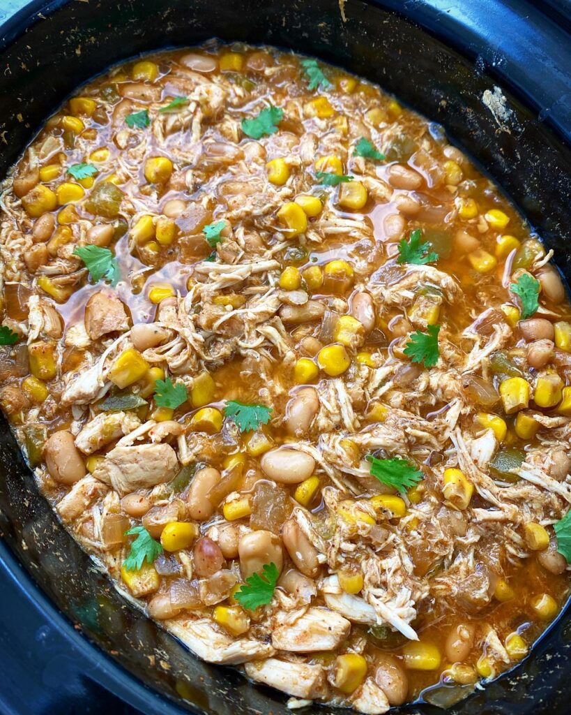 overhead shot of cooked white chicken chili in a black slow cooker