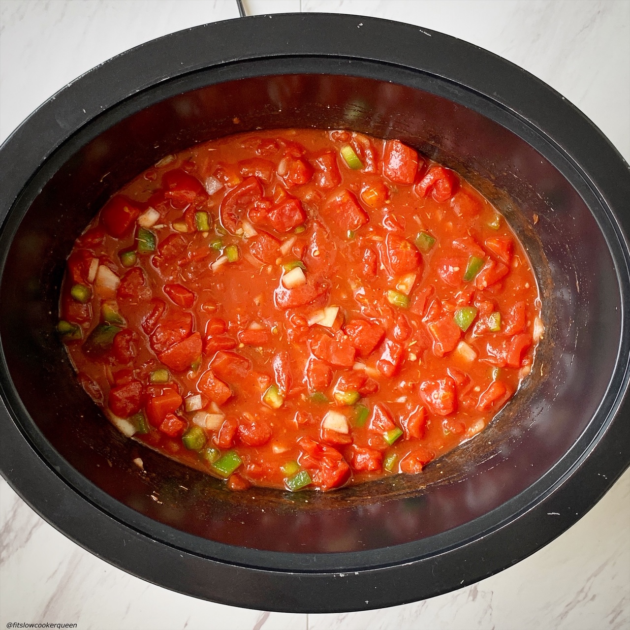 tomatoes, bell peppers, onions, and seasonings in the slow cooker