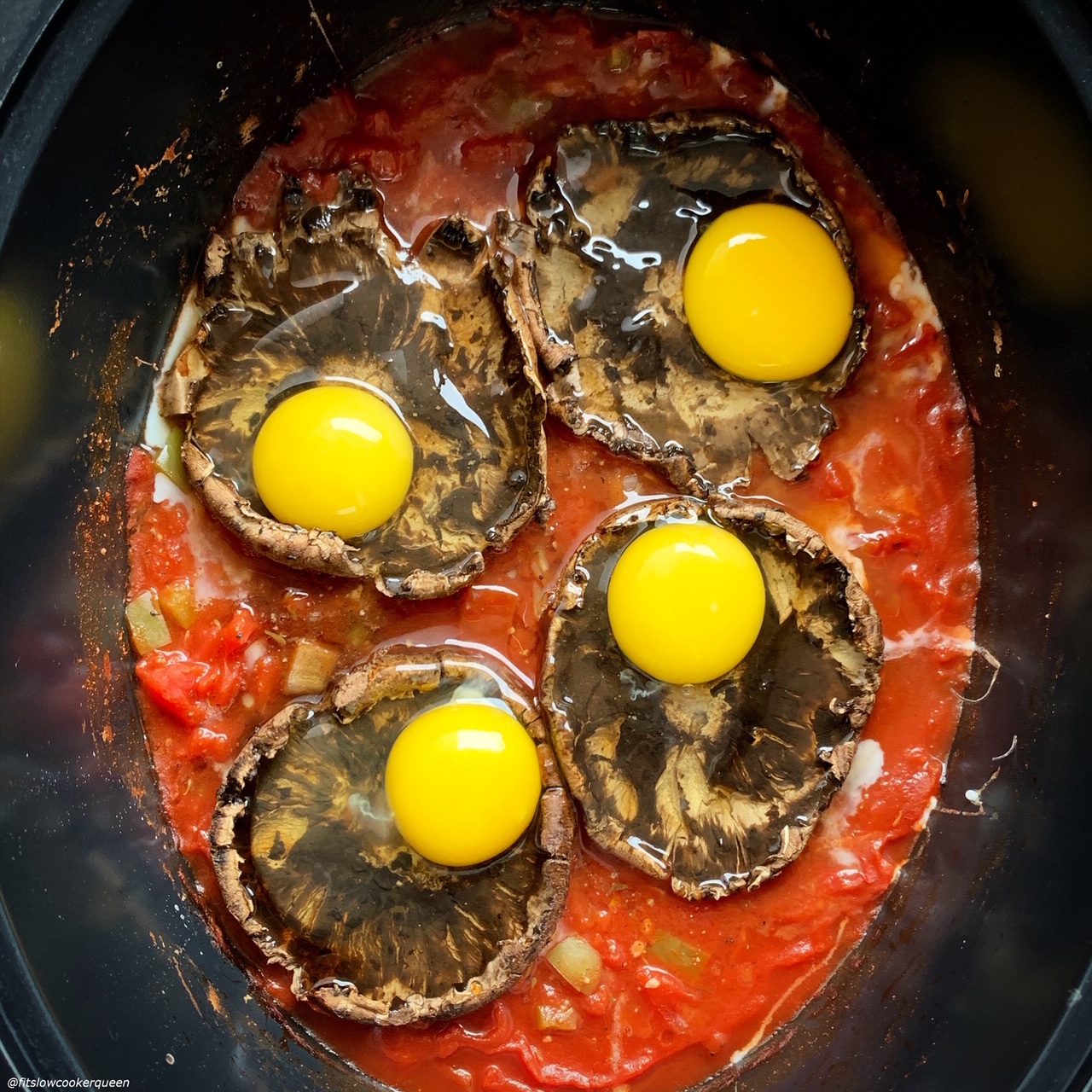 raw eggs added on top of cooked portobello mushrooms in the slow cooker