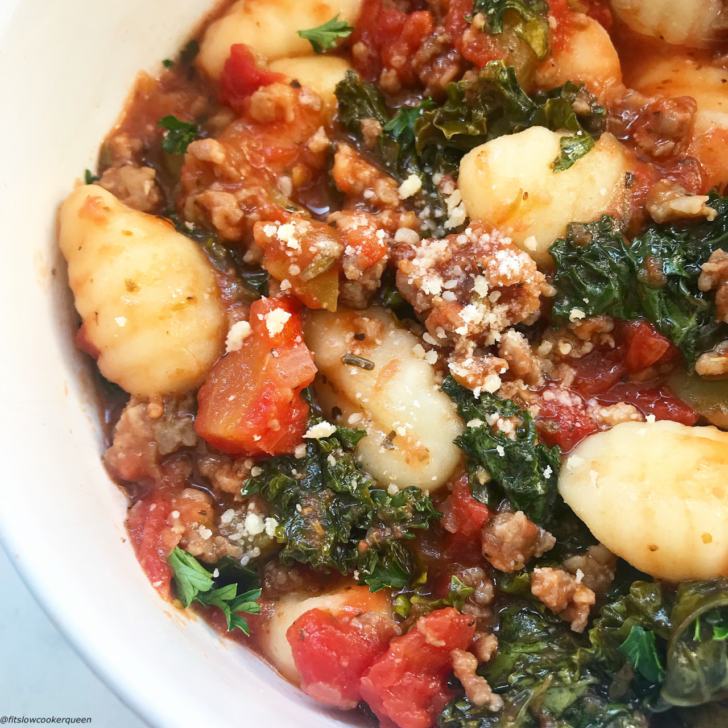 close up shot of Slow Cooker Sausage Gnocchi Kale in a white bowl