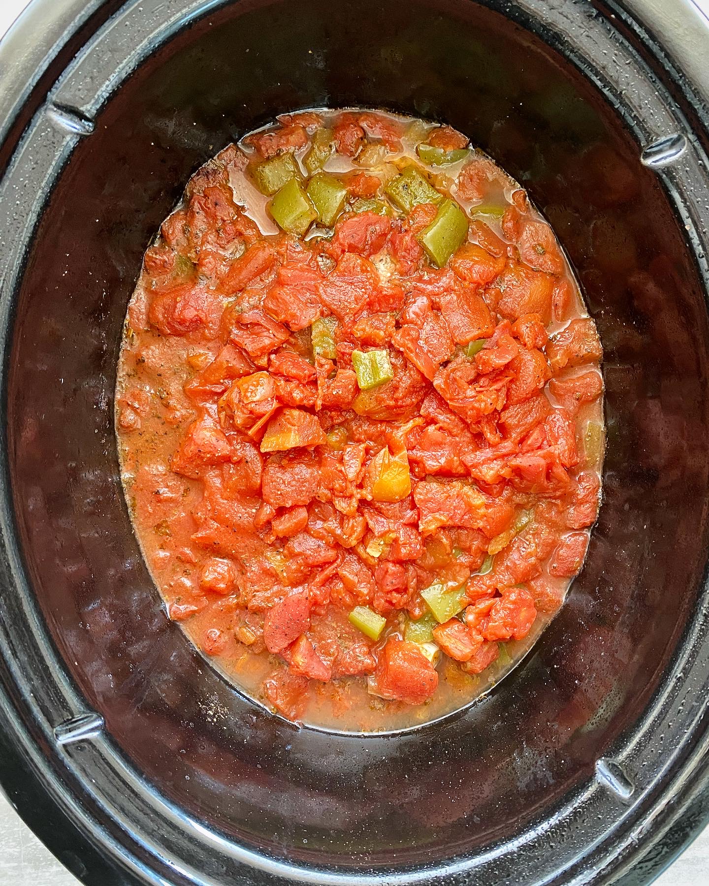 overhead shot of uncooked Mediterranean Salmon in a black slow cooker