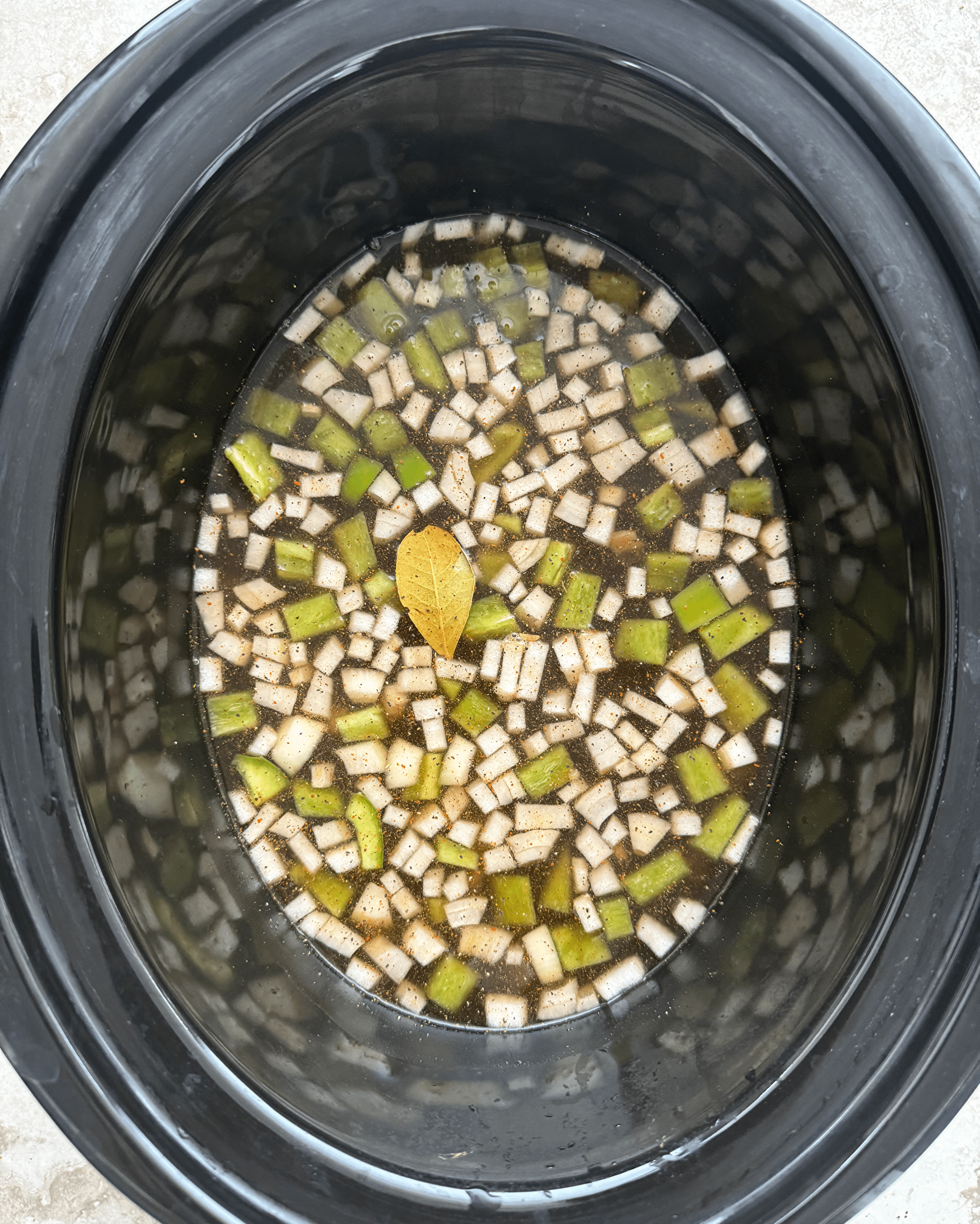 overhead shot of uncooked mexican black beans and rice in a black slow cooker
