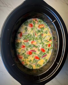 overhead shot of uncooked gg White Fritatta in a black slow cooker