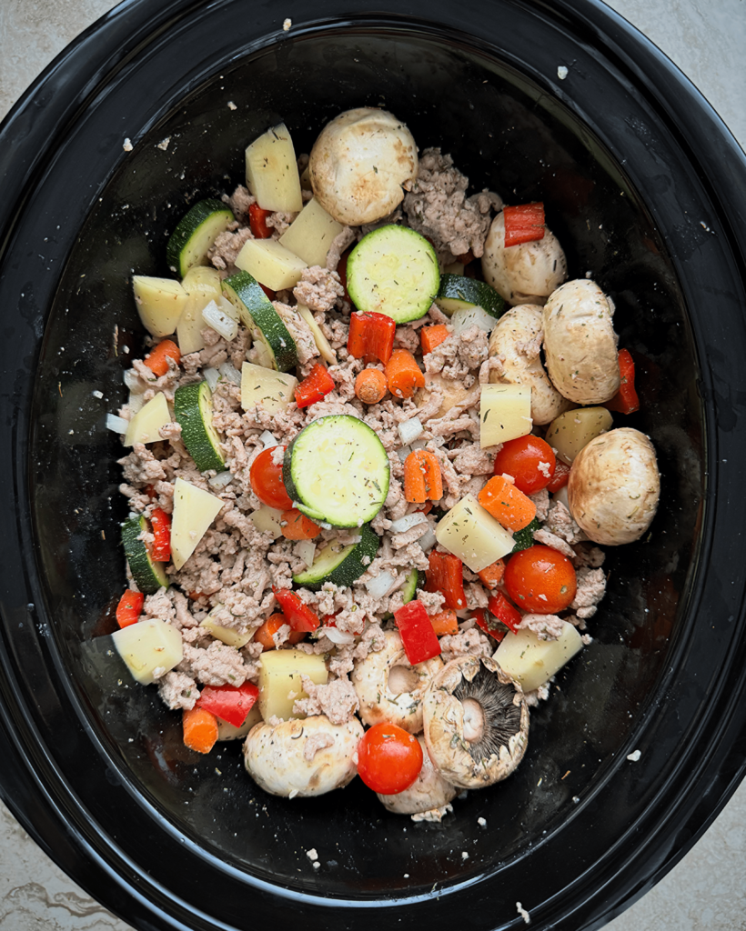 overhead shot of uncooked slow cooker ground turkey bowl in a black slow cooker