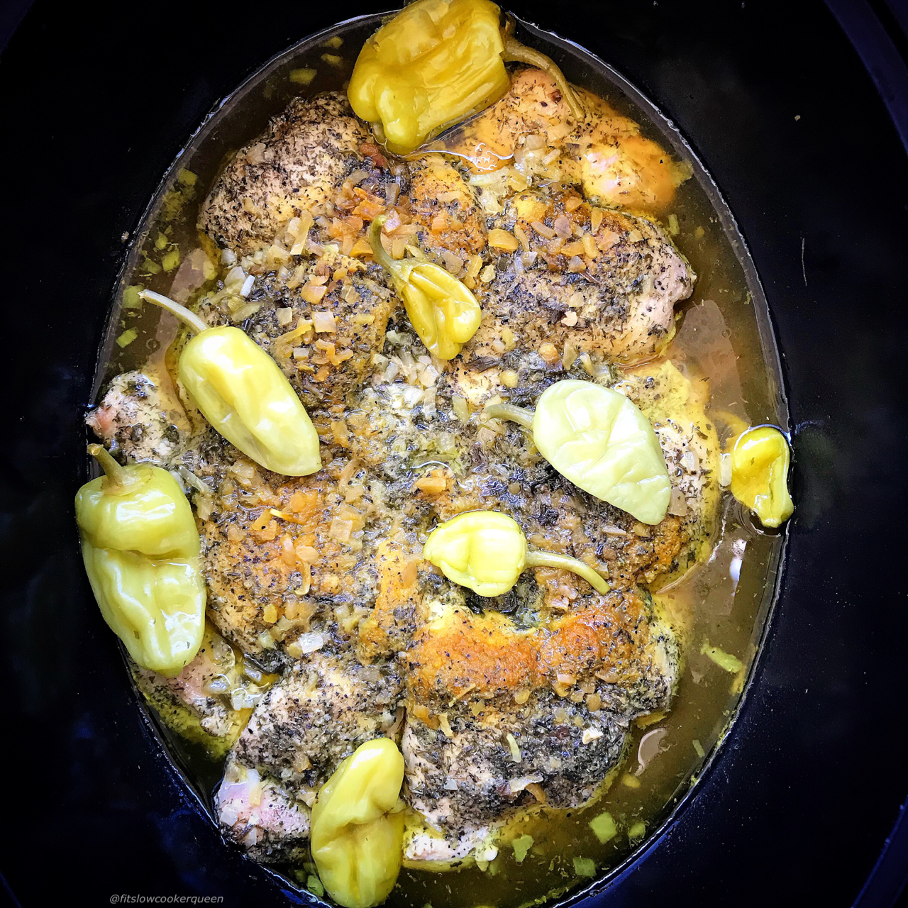 overhead side shot of cooked Mississippi chicken in a black slow cooker