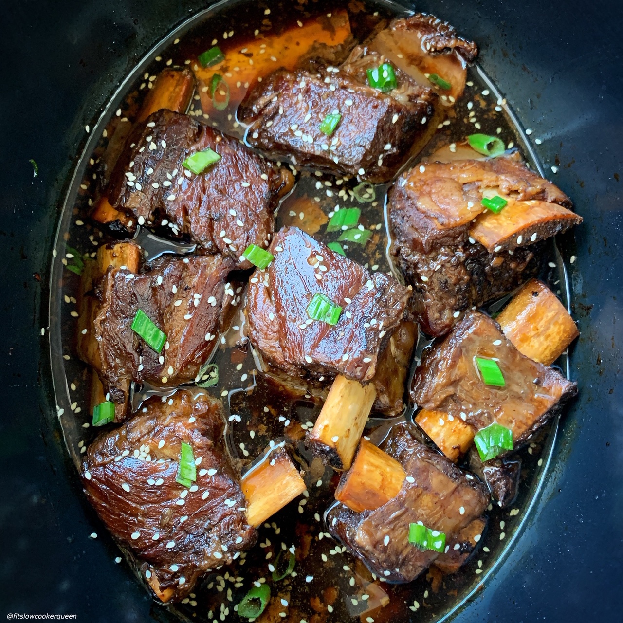 overhead shot of Korean inspired short ribs garnished with sesame seeds and sliced green onions 
