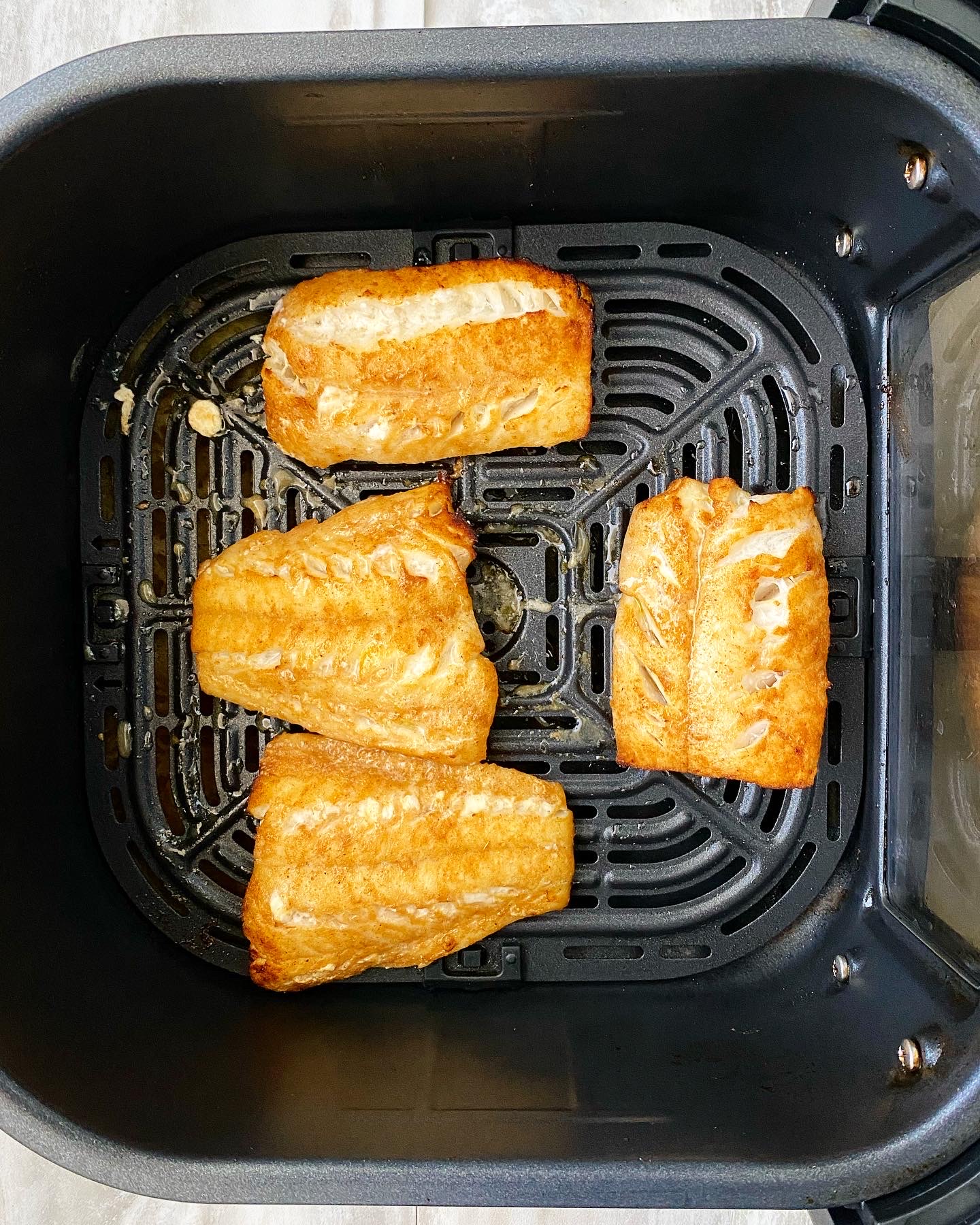 cooked Cumin Paprika Lime White Fish in the air fryer basket