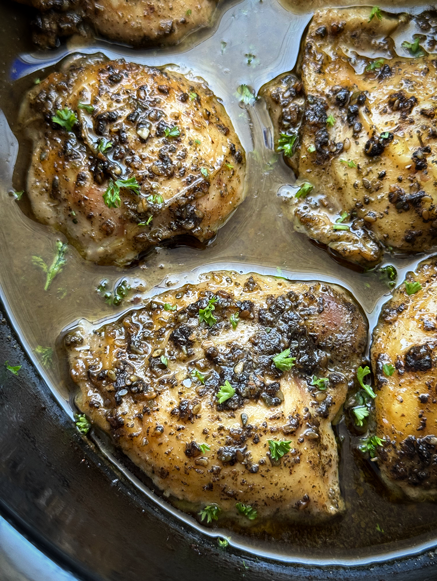 close up shot of cooked zaatar chicken in a black slow cooker