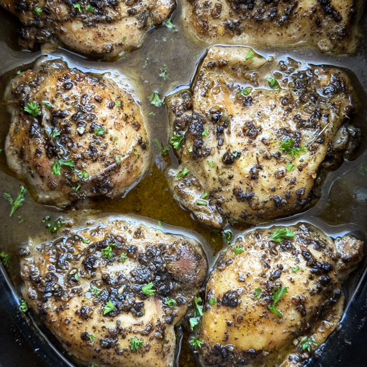 overhead close up shot of cooked zaatar chicken in a black slow cooker