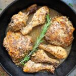 overhead shot of rosemary Dijon chicken in a black cast iron pan