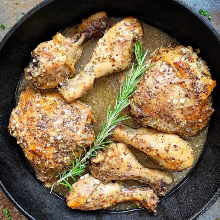 overhead shot of rosemary Dijon chicken in a black cast iron pan