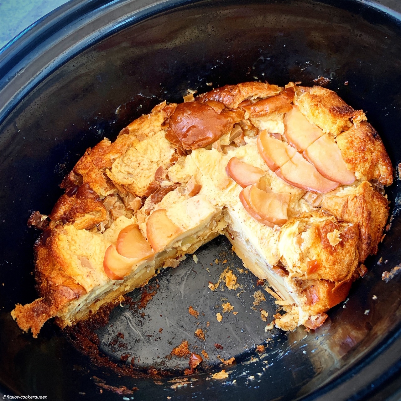cooked Slow Cooker Apples & Honey Challah Bread Pudding in the slow cooker with a piece missing