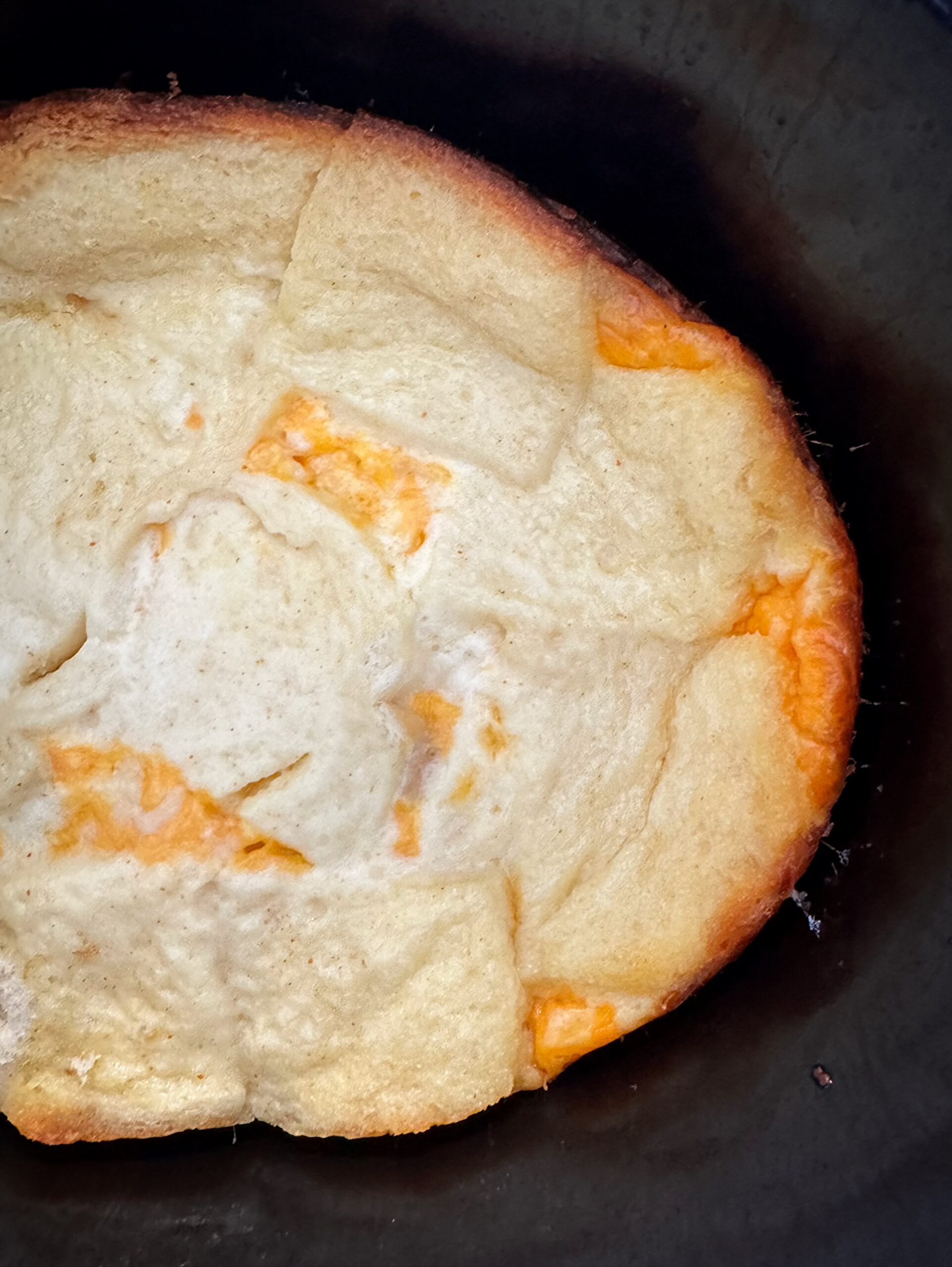 close up, overhead shot of overhead shot of cooked overhead of Cheese Souffle in a black slow cooker