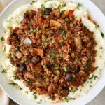 overhead shot of supreme pizza stew served over mashed potatoes