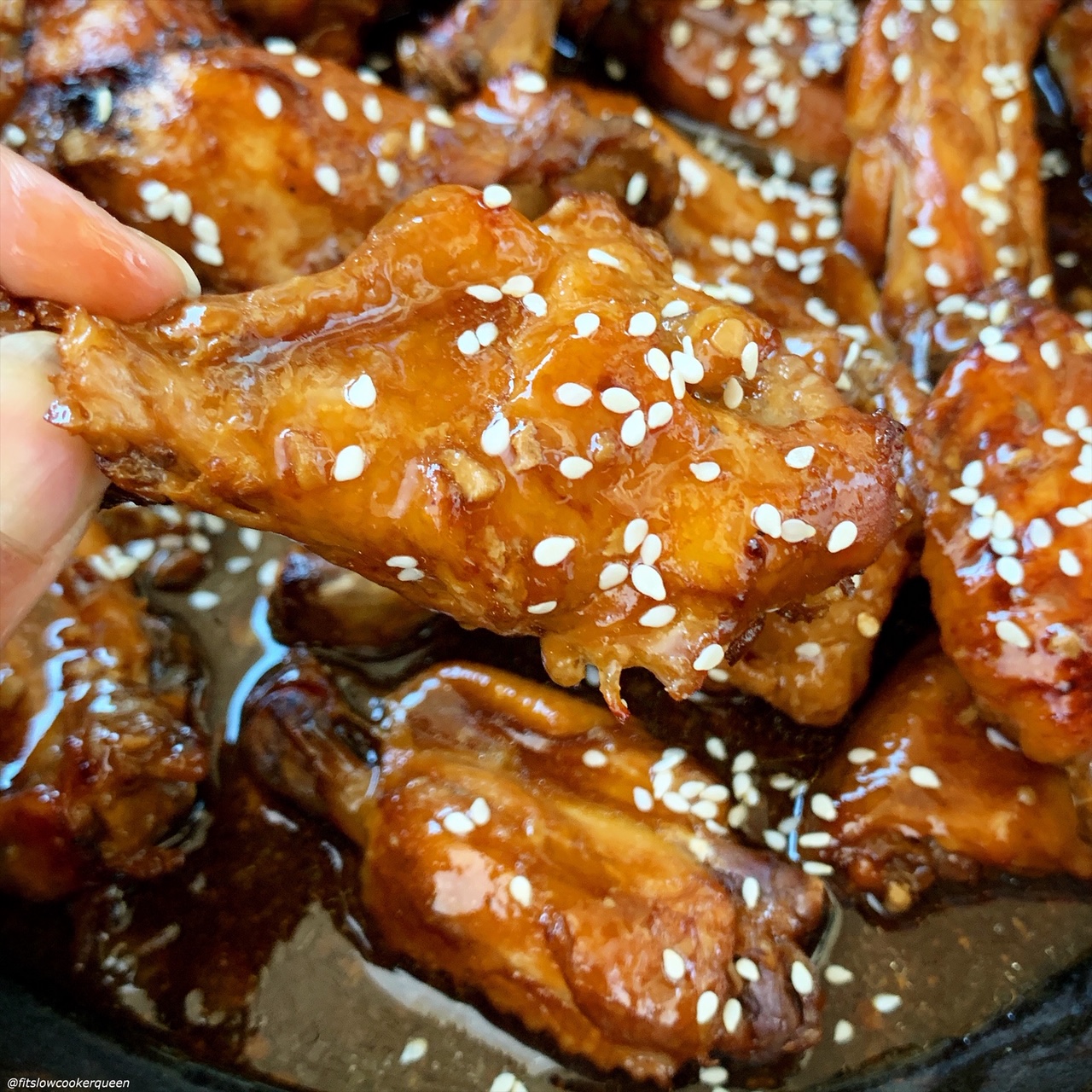 teriyaki chicken wings being held up
