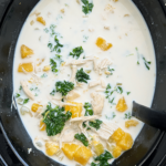 overhead shot of cooked Crockpot Chicken Butternut Squash Soup in a black slow cooker