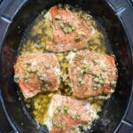 overhead shot of cooked Crockpot Prosciutto Wrapped Chicken in a black slow cooker