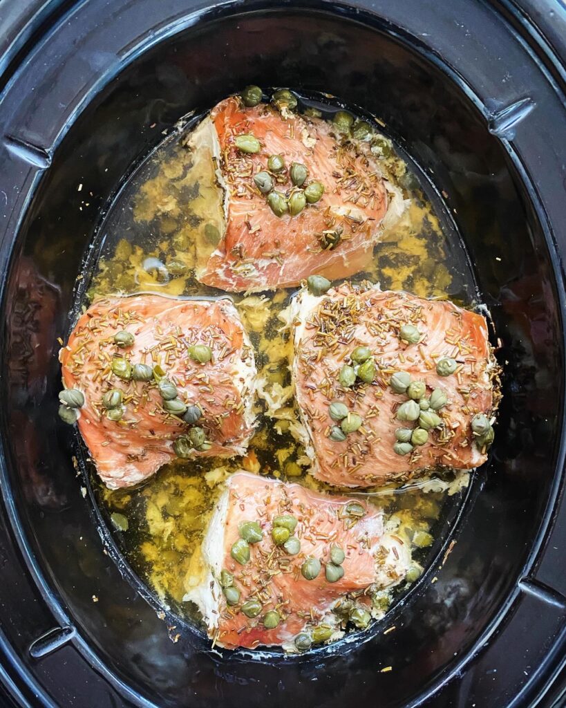 overhead shot of cooked Crockpot Prosciutto Wrapped Chicken in a black slow cooker