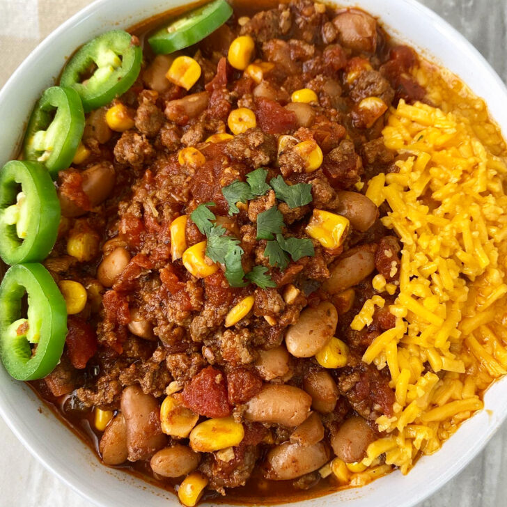 close up of overhead shot of taco chili in a white bowl with a jalapeno with cheese