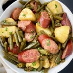 overhead shot of cooked Crockpot Sausage, Potatoes Green Beans in a white bowl