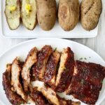 cooked ribs & potatoes on white plate
