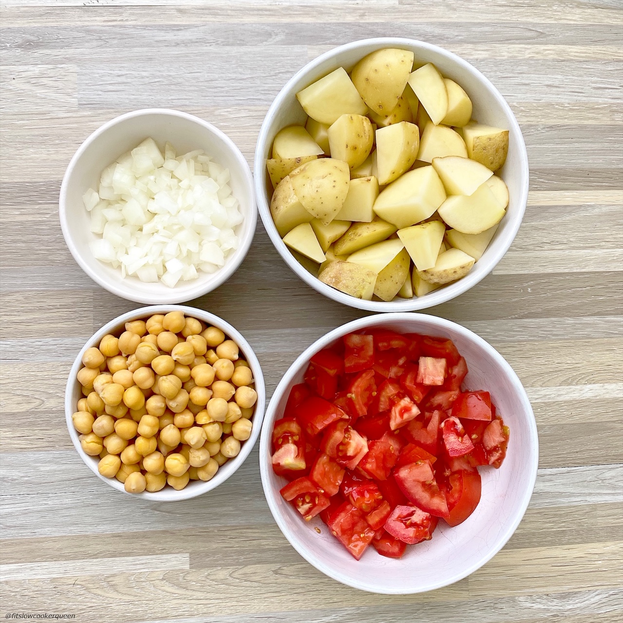 in separate white bowls: diced roma tomatoes, chickpeas, diced yellow potatoes, diced onion